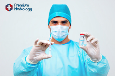 Врач в медицинской маске со шприцом в руке